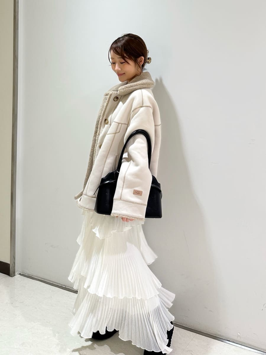 ホワイト系のスカート、ホワイト系のTシャツ/カットソー、ブラック系のボストンバッグを着用したレディースの秋コーディネートの4枚目の写真