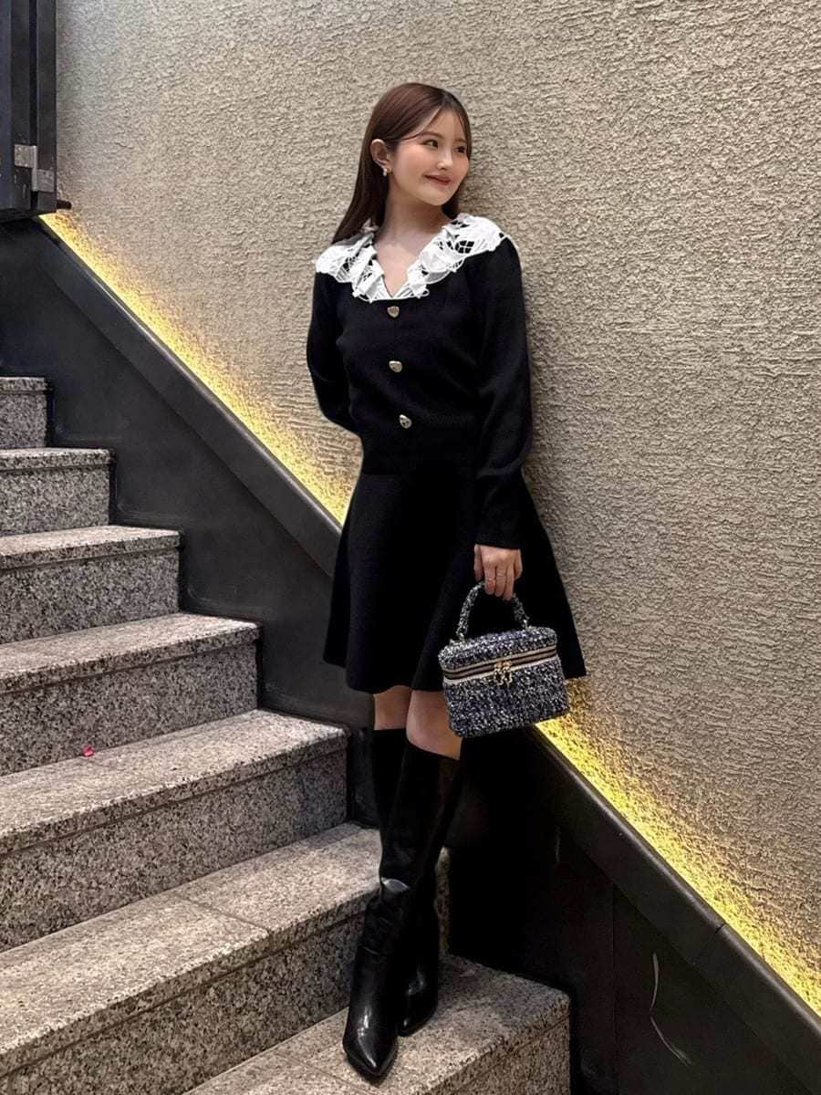 ブラック系のブーツ、ブルー系のハンドバッグ、ブラック系のワンピースを着用したレディースの冬コーディネートの2枚目の写真