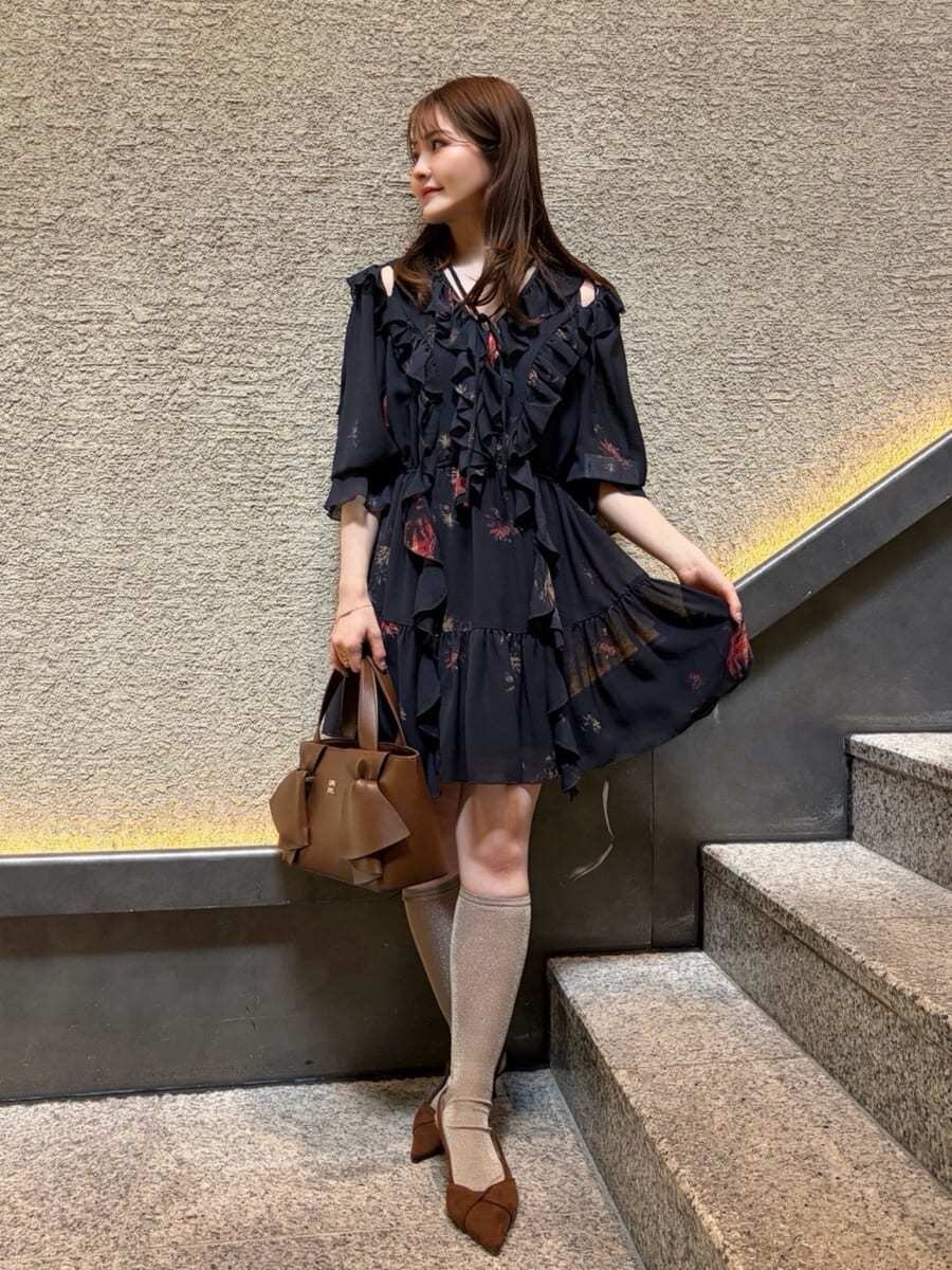 ブラック系のその他トップス、ブラウン系のパンプス、ブラウン系のハンドバッグを着用したレディースの春コーディネートの2枚目の写真