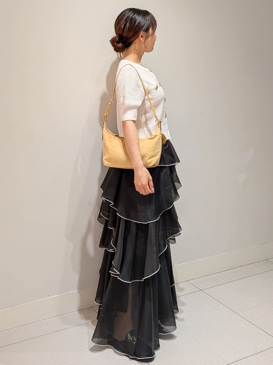 ブラック系のスカート、ホワイト系のカーディガン/ボレロ、イエロー系のショルダーバッグを着用したレディースの夏コーディネートの2枚目の写真