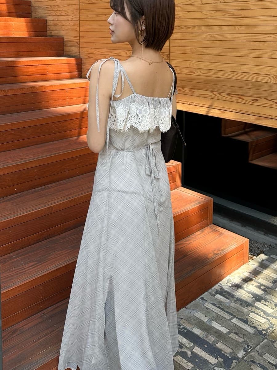 ベージュ系のワンピース、ブラウン系のブーツ、ブラウン系のボストンバッグを着用したレディースの夏コーディネートの5枚目の写真