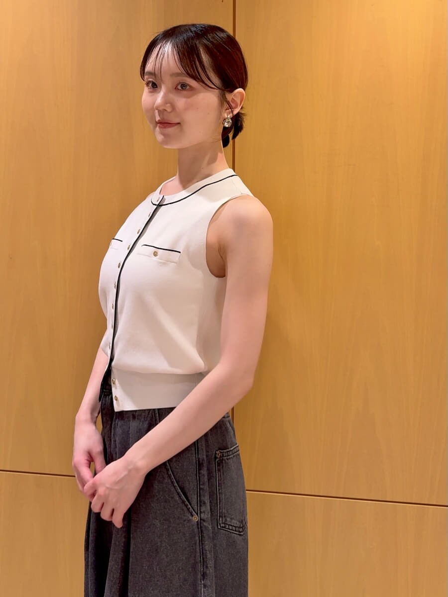 ブラック系のかごバッグ、ブラック系のデニムパンツ、ホワイト系のニット/セーターを着用したレディースの夏コーディネートの5枚目の写真