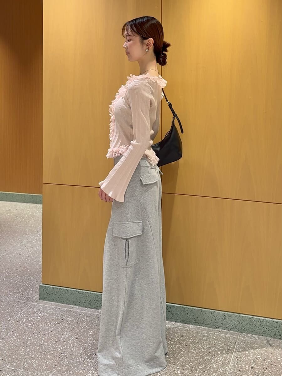 グレー系のその他パンツ、ピンク系のニット/セーター、ブラック系のショルダーバッグを着用したレディースの夏コーディネートの3枚目の写真