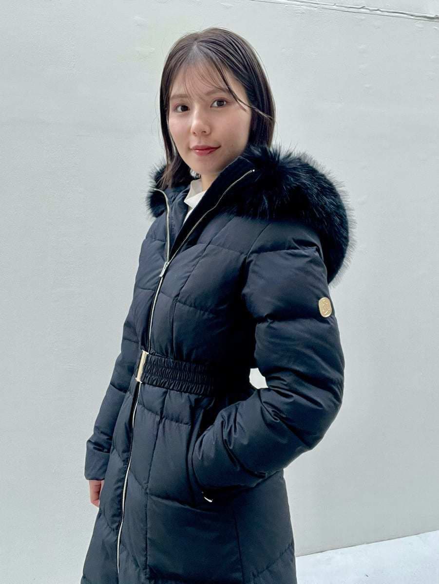 ホワイト系のスカート、ブラック系のブーツ、ブラック系のダウンジャケット/コートを着用したレディースの冬コーディネートの8枚目の写真