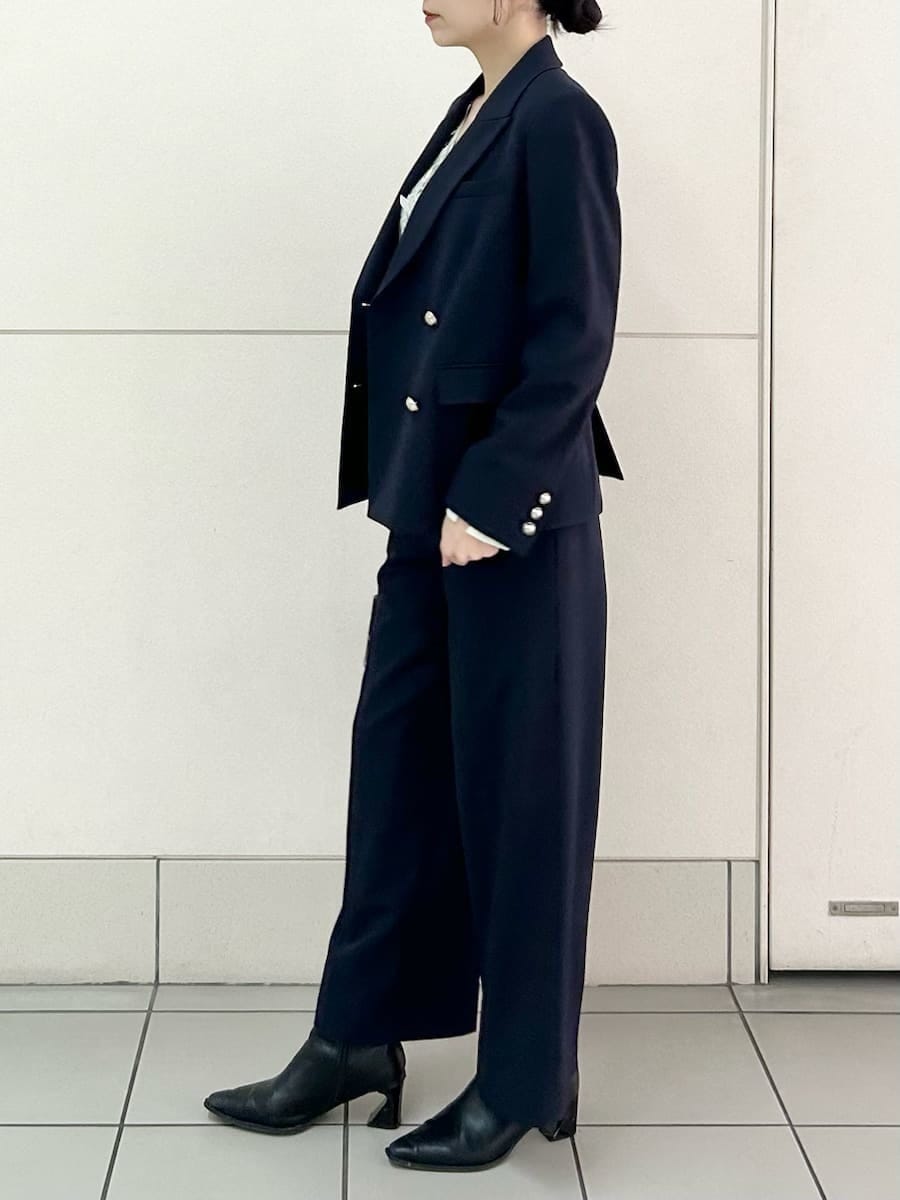 ブルー系のテーラードジャケット、ブルー系のスラックス、ブラック系のハンドバッグを着用したレディースの冬コーディネートの4枚目の写真