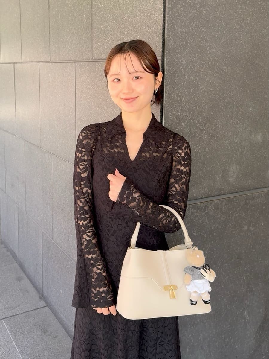 グレー系のブーツ、ブラック系のワンピース、ホワイト系のハンドバッグを着用したレディースの冬コーディネートの5枚目の写真