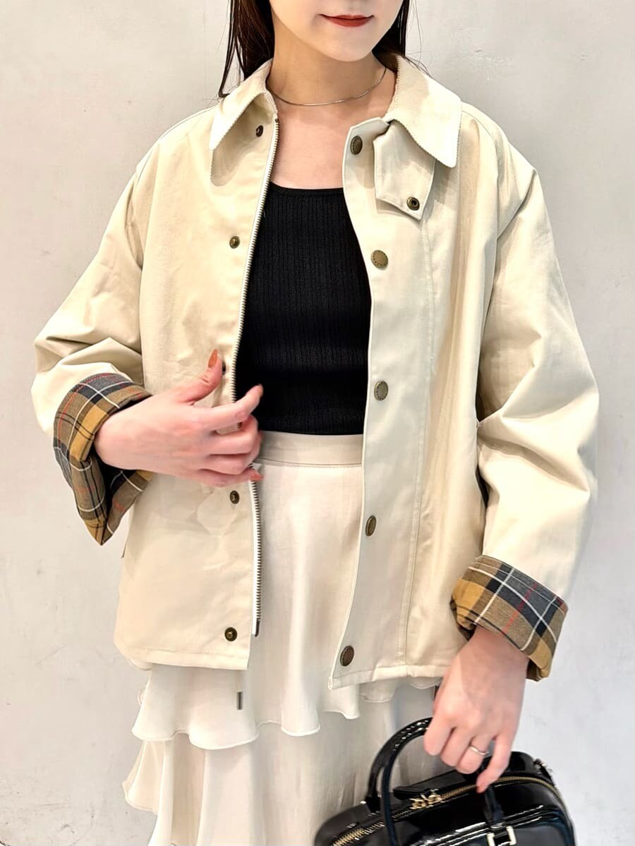 ホワイト系のブルゾン、ブラック系のニット/セーター、ホワイト系のスカートを着用したレディースの秋コーディネートの4枚目の写真