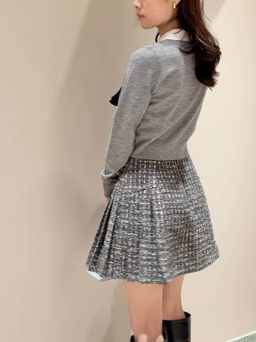 ブラック系のブーツ、グレー系のスカート、ブルー系のハンドバッグを着用したレディースの冬コーディネートの4枚目の写真