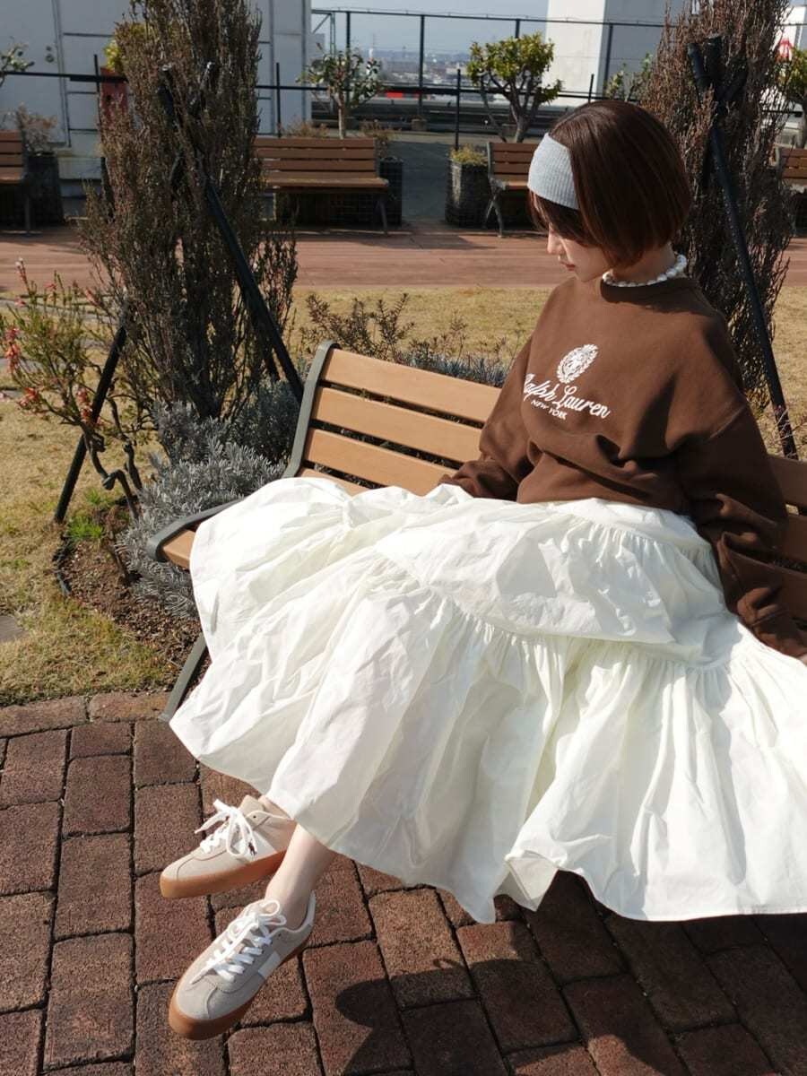 ホワイト系のスカート、ブラウン系のスウェット、ベージュ系のスニーカーを着用したレディースの春コーディネートの7枚目の写真