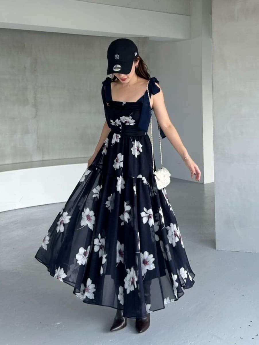 ブルー系のワンピース、ホワイト系のショルダーバッグ、ブラック系のブーツを着用したレディースの夏コーディネートの3枚目の写真