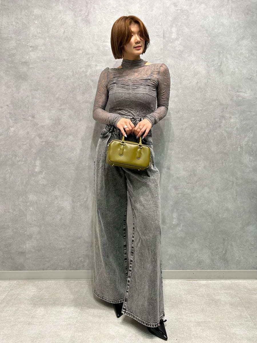 グレー系のTシャツ/カットソー、グレー系のデニムパンツ、グリーン系のボストンバッグを着用したレディースの秋コーディネートの3枚目の写真