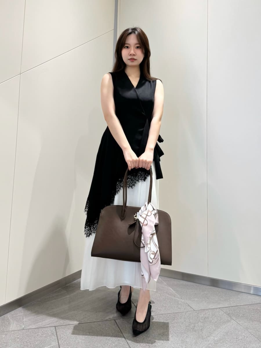 ブラック系のワンピース、ブラウン系のトートバッグ、ピンク系のバンダナ/スカーフを着用したレディースの春コーディネートの2枚目の写真
