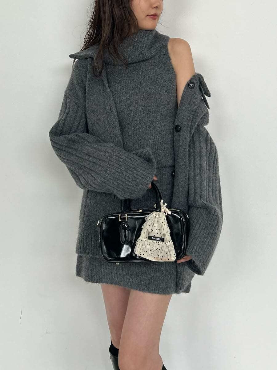 グレー系のカーディガン/ボレロ、グレー系のワンピース、ブラック系のボストンバッグを着用したレディースの夏コーディネートの9枚目の写真