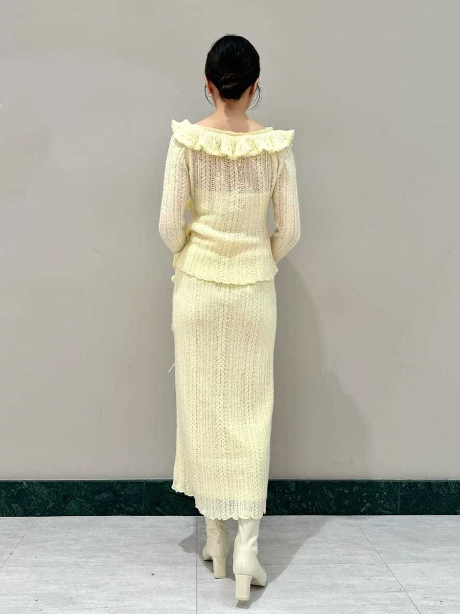 イエロー系のスカート、イエロー系のニット/セーター、ホワイト系のハンドバッグを着用したレディースの秋コーディネートの3枚目の写真