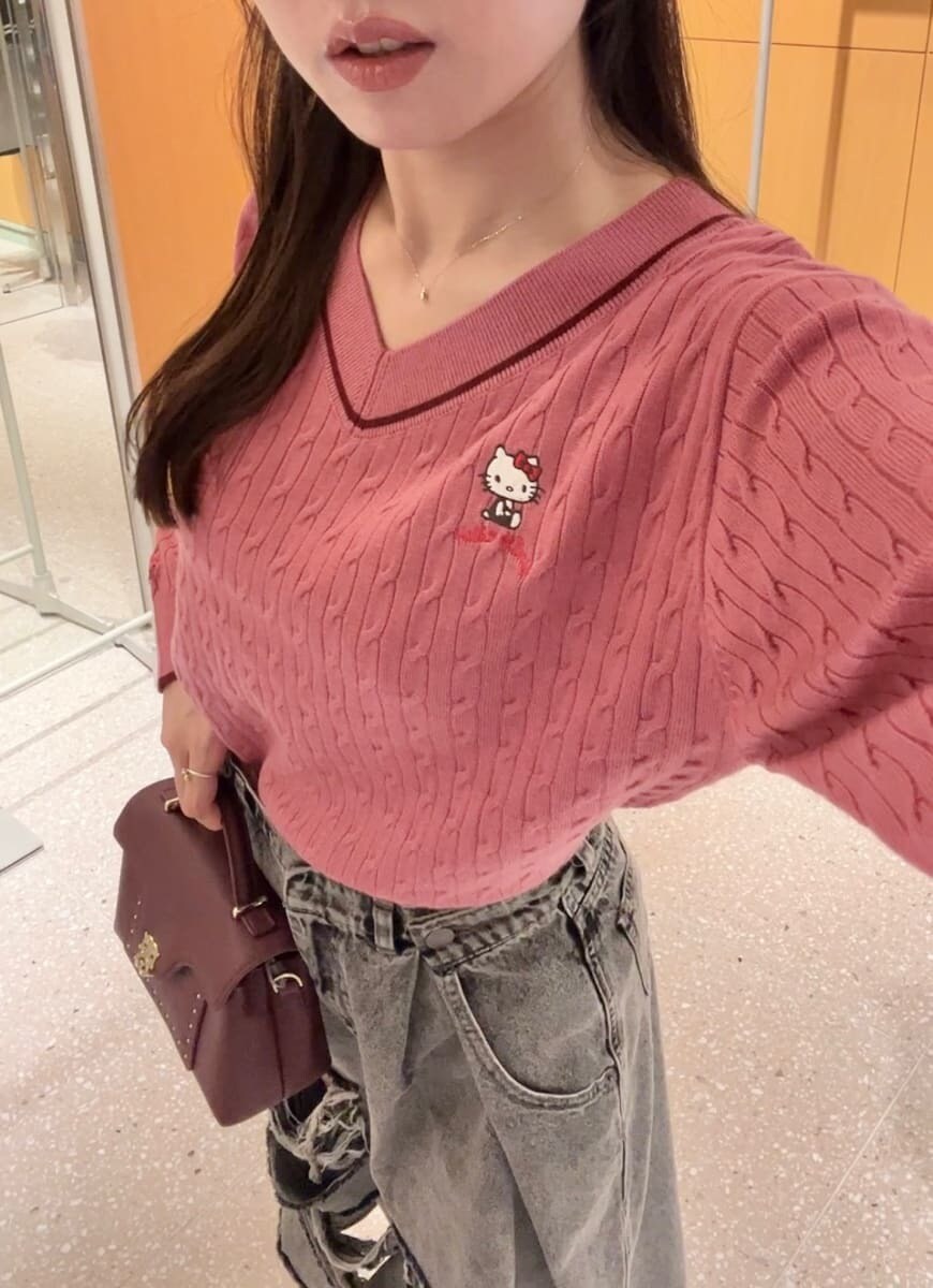 ピンク系のニット/セーター、グレー系のデニムパンツ、ブラウン系のショルダーバッグを着用したレディースの秋コーディネートの8枚目の写真