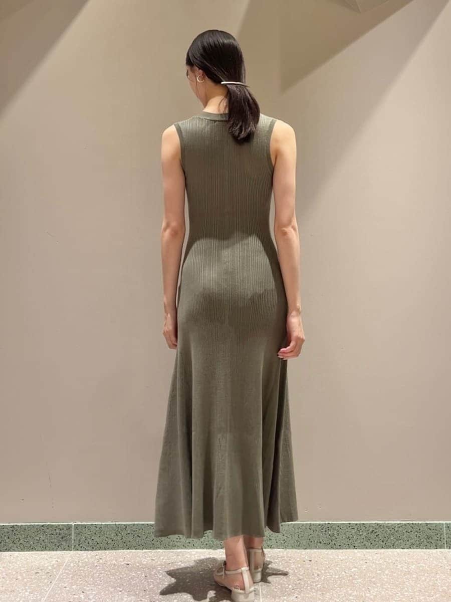 ベージュ系のテーラードジャケット、グリーン系のワンピース、ホワイト系のショルダーバッグを着用したレディースの夏コーディネートの9枚目の写真