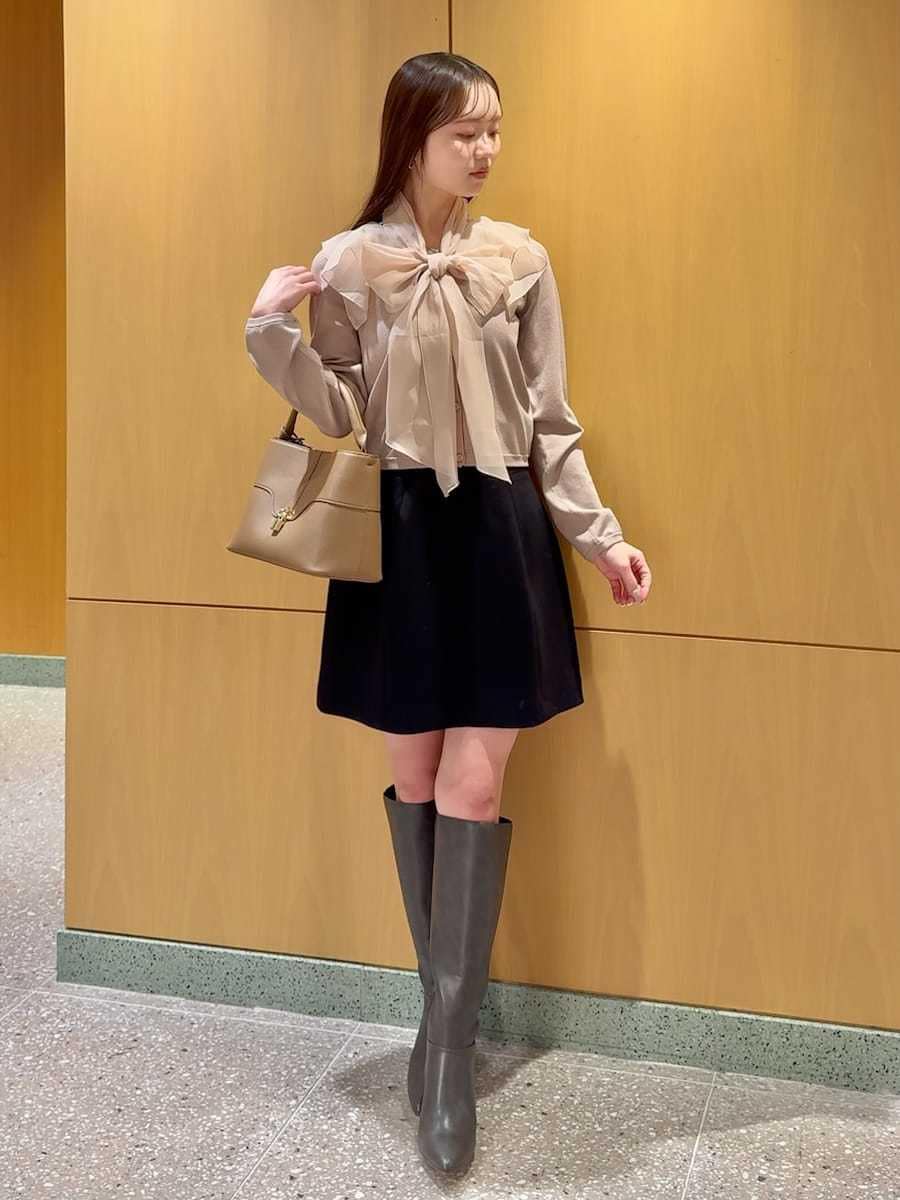 グレー系のブーツ、ピンク系のニット/セーター、ブラック系のスカートを着用したレディースの冬コーディネートの2枚目の写真