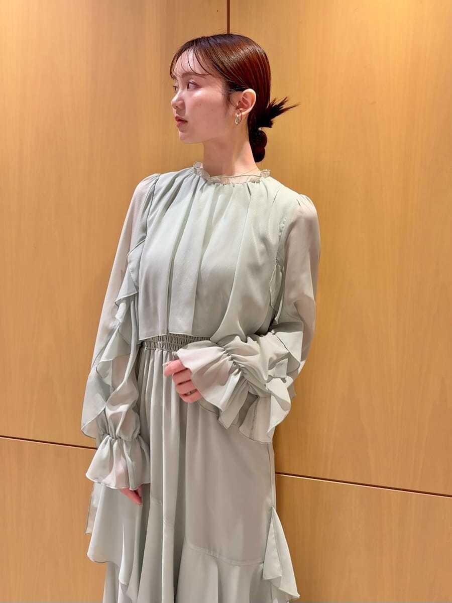 グリーン系のワンピース、ホワイト系のカーディガン/ボレロを着用したレディースの冬コーディネートの8枚目の写真