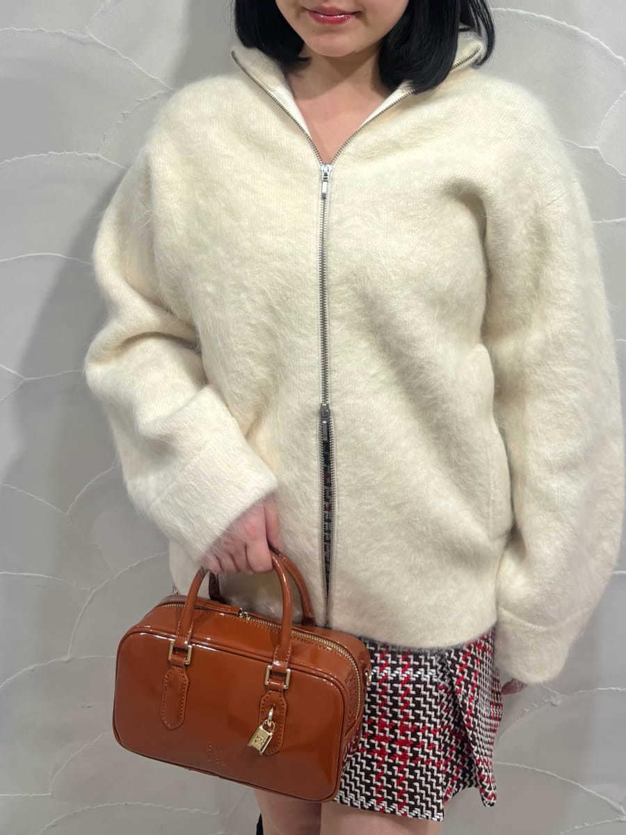 ホワイト系のブルゾン、レッド系のスカート、ブラック系のブーツを着用したレディースの冬コーディネートの3枚目の写真