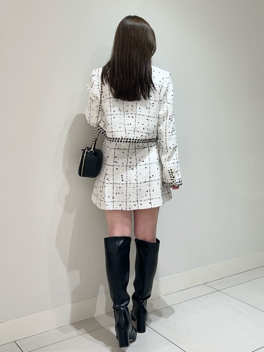 ホワイト系のノーカラージャケット、ホワイト系のその他パンツ、ブラック系のニット/セーターを着用したレディースの秋コーディネートの4枚目の写真