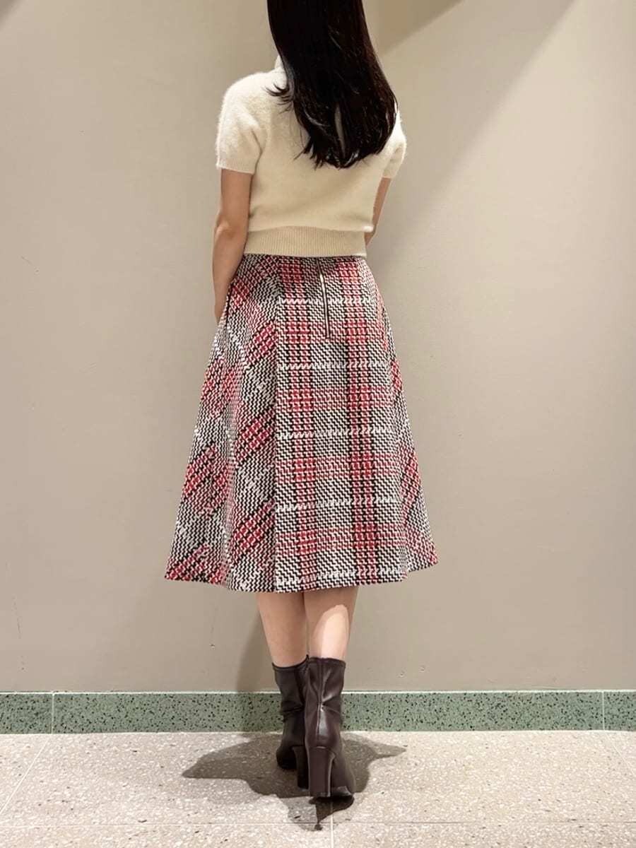 ベージュ系のニット/セーター、レッド系のスカート、ブラウン系のハンドバッグを着用したレディースの秋コーディネートの2枚目の写真