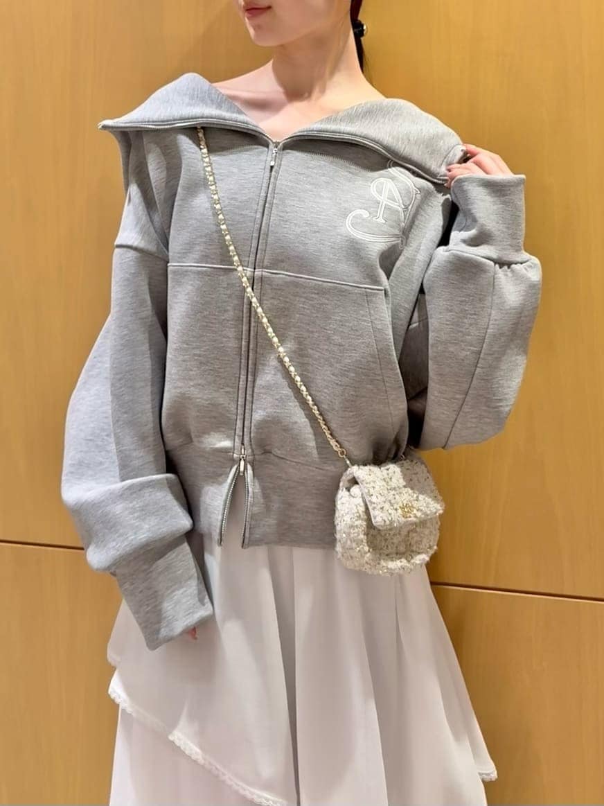 ホワイト系のショルダーバッグ、ホワイト系のスカート、グレー系のパーカーを着用したレディースの冬コーディネートの4枚目の写真