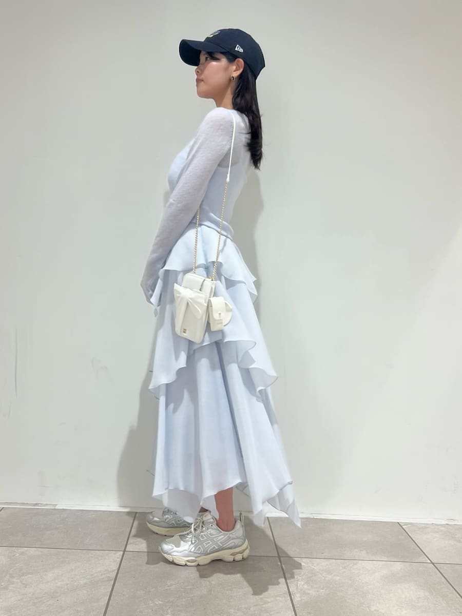 ブルー系のワンピース、ホワイト系のショルダーバッグ、シルバー系のスニーカーを着用したレディースの冬コーディネートの2枚目の写真