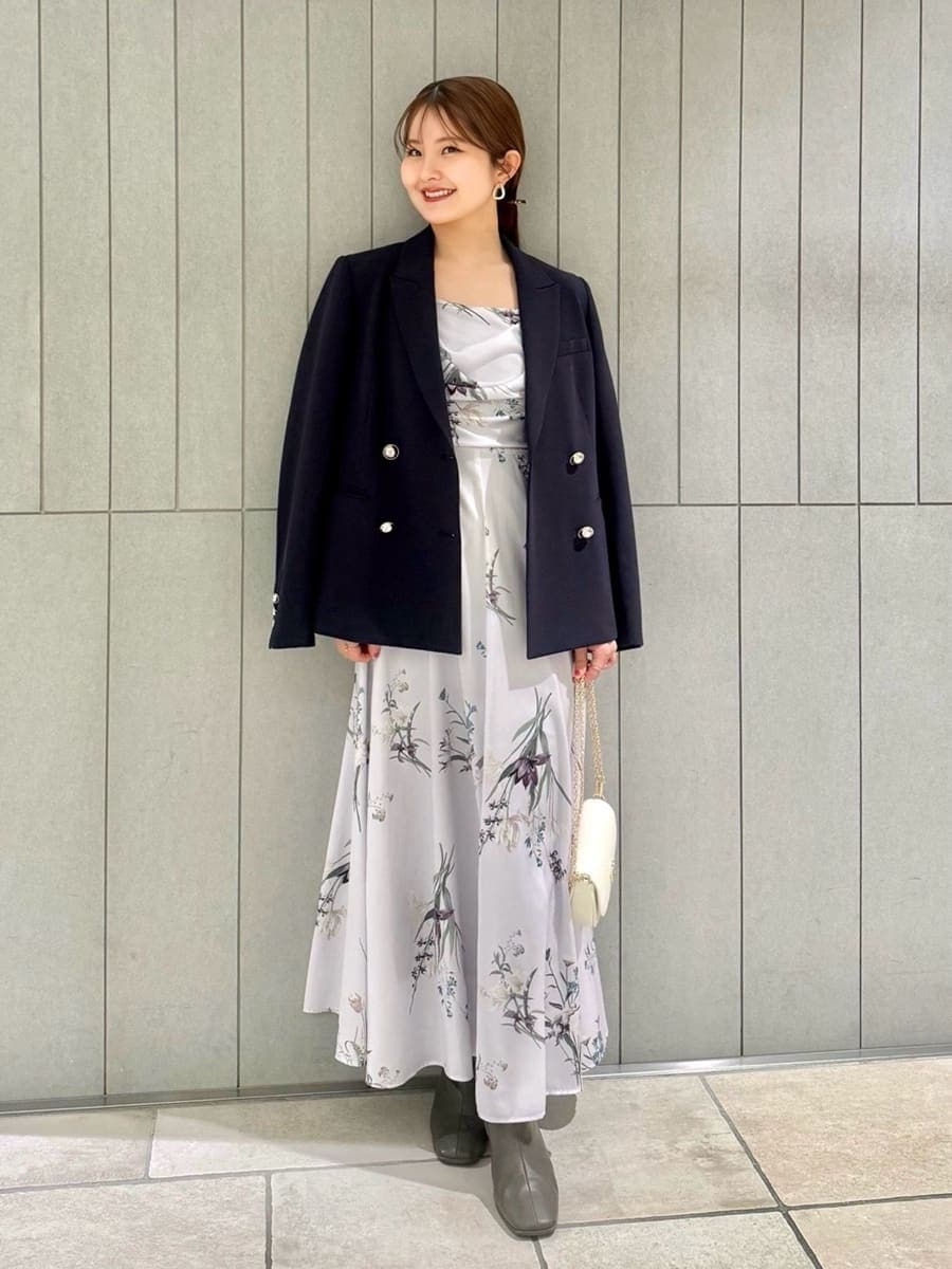 ブルー系のテーラードジャケット、パープル系のワンピース、ホワイト系のショルダーバッグを着用したレディースの春コーディネートの4枚目の写真