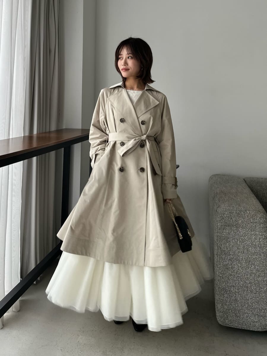 ベージュ系のトレンチコート、ベージュ系のワンピース、ブラック系のショルダーバッグを着用したレディースの春コーディネートの4枚目の写真