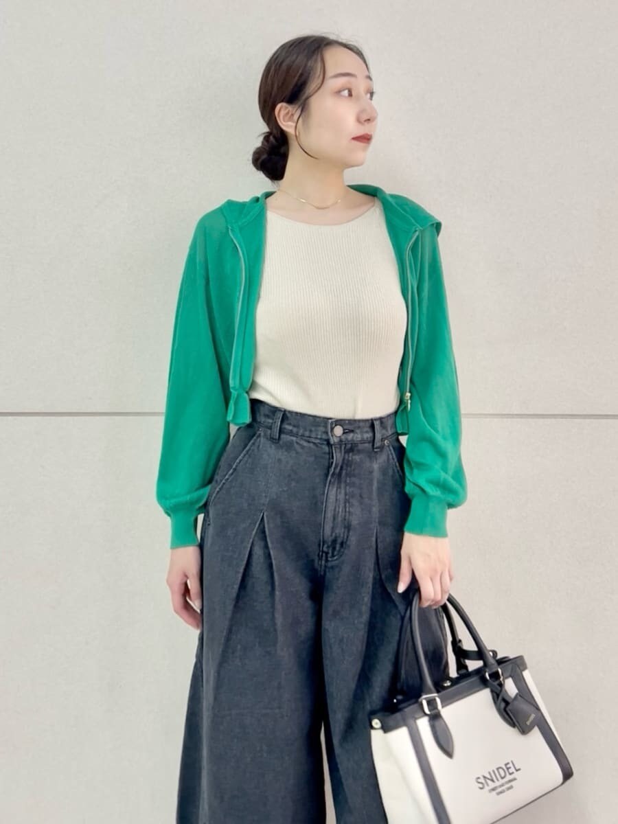 ブラック系のデニムパンツ、ベージュ系のニット/セーター、ブラック系のハンドバッグを着用したレディースの夏コーディネートの6枚目の写真