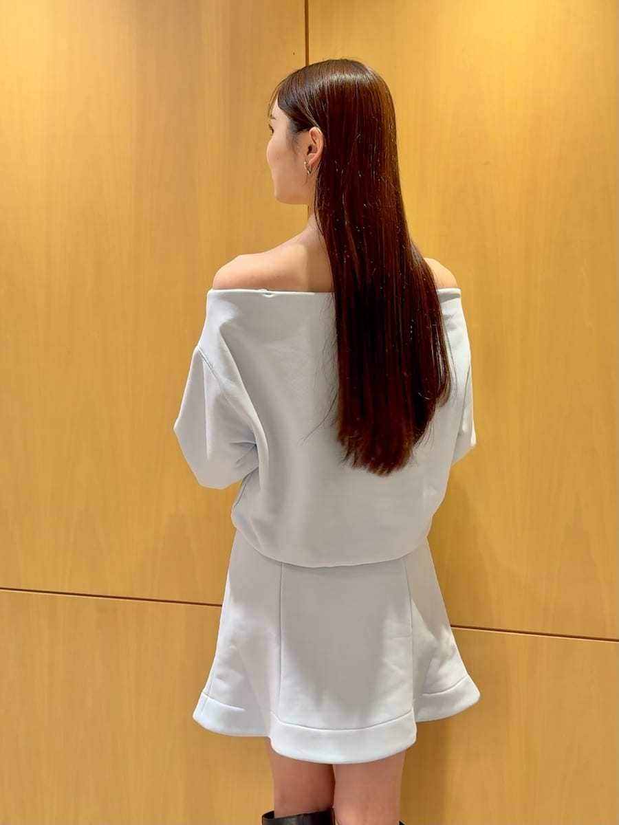 ブラック系のブーツ、ホワイト系のダウンジャケット/コート、ブルー系のワンピースを着用したレディースの冬コーディネートの7枚目の写真