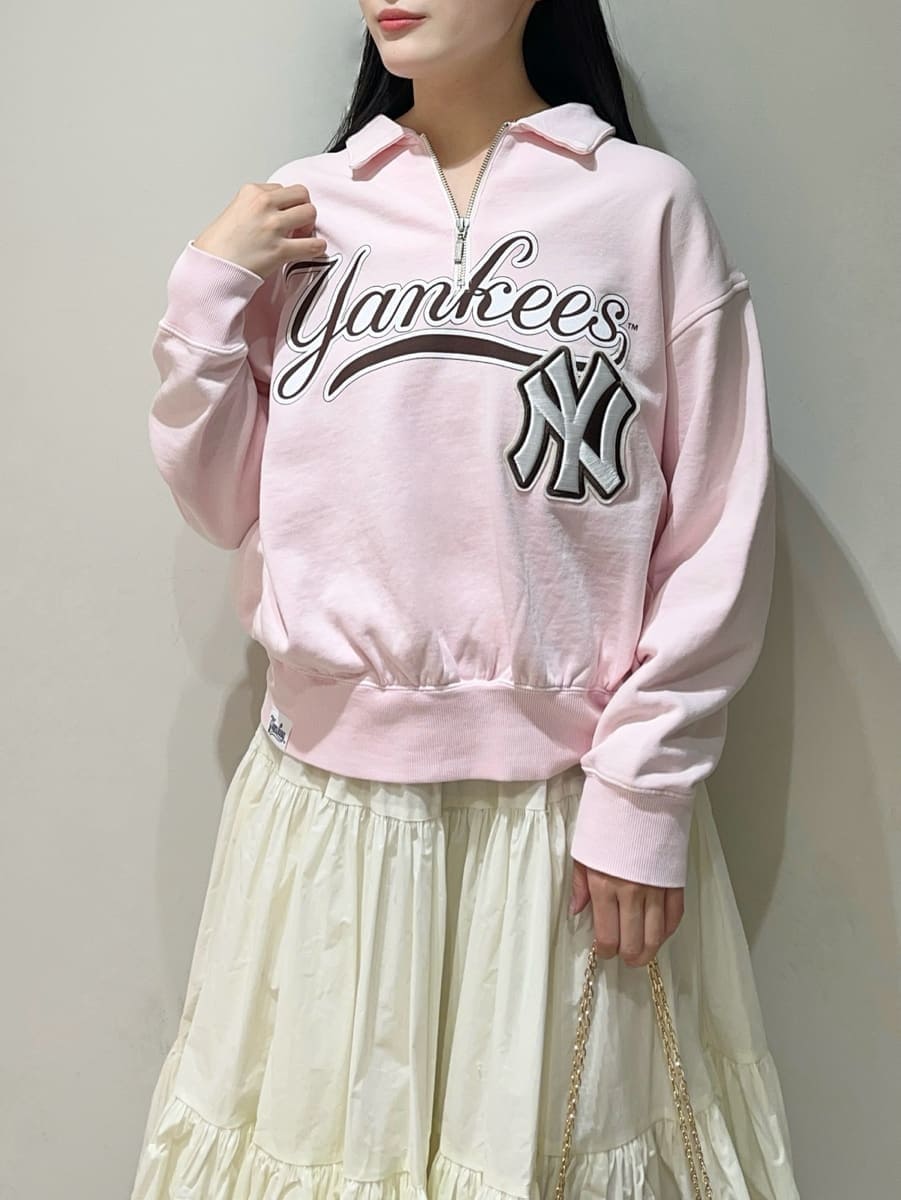 ホワイト系のスカート、ピンク系のスウェット、ブラック系のショルダーバッグを着用したレディースの春コーディネートの3枚目の写真