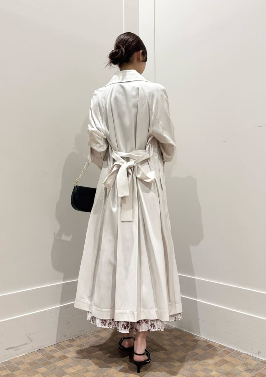 ホワイト系のトレンチコート、ピンク系のワンピース、ブラック系のパンプスを着用したレディースの冬コーディネートの4枚目の写真