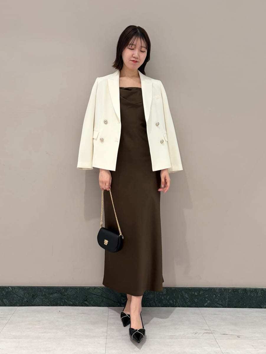 ホワイト系のテーラードジャケット、ブラック系のパンプス、ブラック系のショルダーバッグを着用したレディースの春コーディネートの7枚目の写真