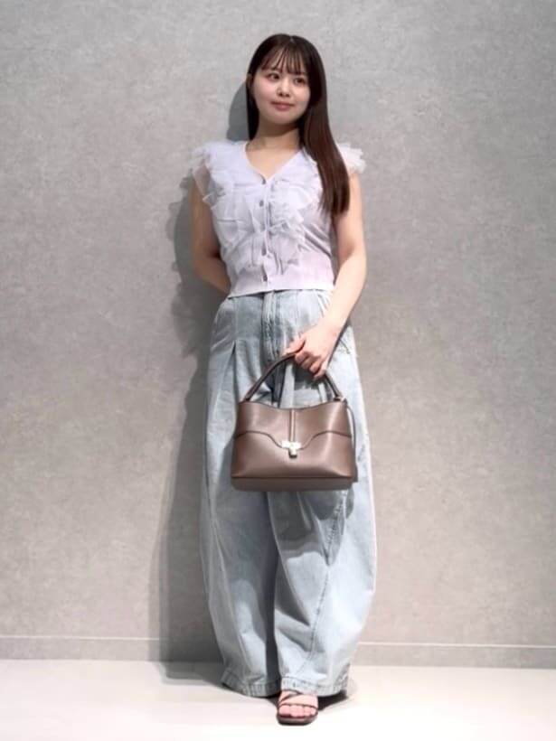 ブラウン系のハンドバッグ、ブルー系のデニムパンツ、パープル系のニット/セーターを着用したレディースの夏コーディネートの2枚目の写真