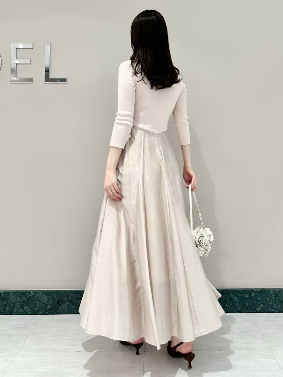 ブラウン系のパンプス、ホワイト系のハンドバッグを着用したレディースの冬コーディネートの5枚目の写真