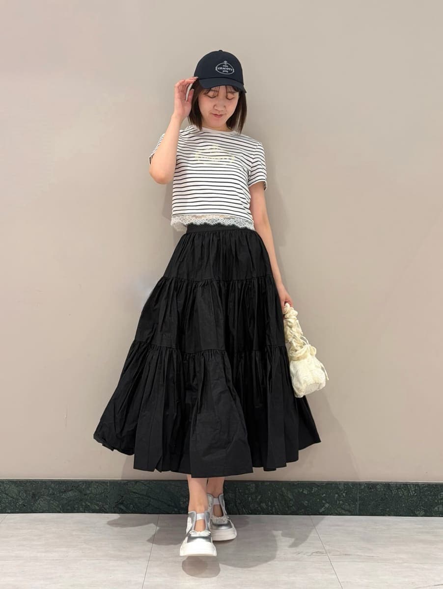 ブラック系のスカート、その他のTシャツ/カットソー、シルバー系のスニーカーを着用したレディースの春コーディネートの5枚目の写真