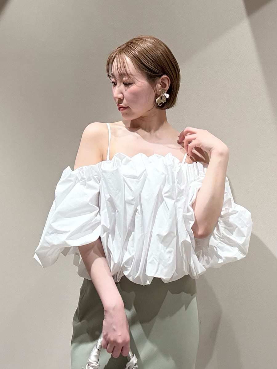 グリーン系のスカート、ホワイト系のシャツ/ブラウス、ホワイト系のハンドバッグを着用したレディースの春コーディネートの7枚目の写真