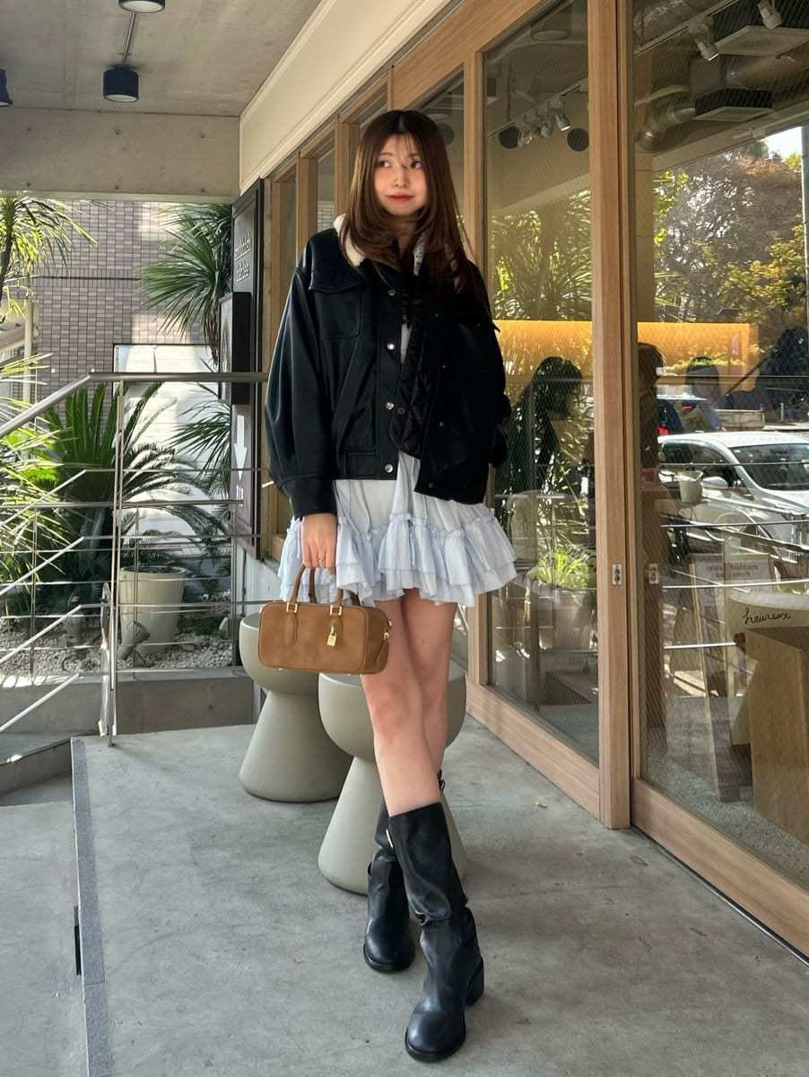 イエロー系のボストンバッグ、ブラック系のブルゾン、ブルー系のその他トップスを着用したレディースの冬コーディネートの2枚目の写真