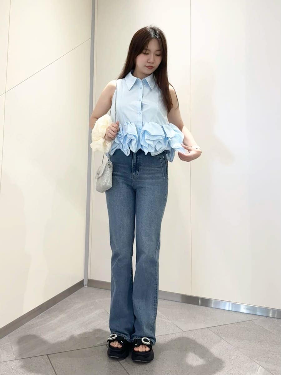 ブルー系のシャツ/ブラウス、ブラック系のサンダル、ブルー系のデニムパンツを着用したレディースの春コーディネートの2枚目の写真