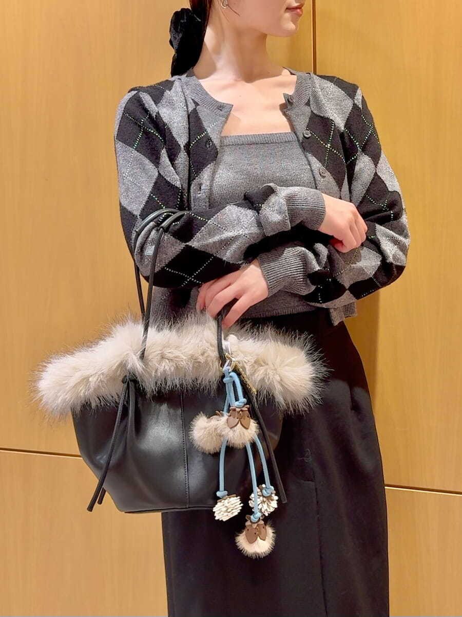 グレー系のブーツ、ブラック系のスカート、グレー系のニット/セーターを着用したレディースの秋コーディネートの7枚目の写真