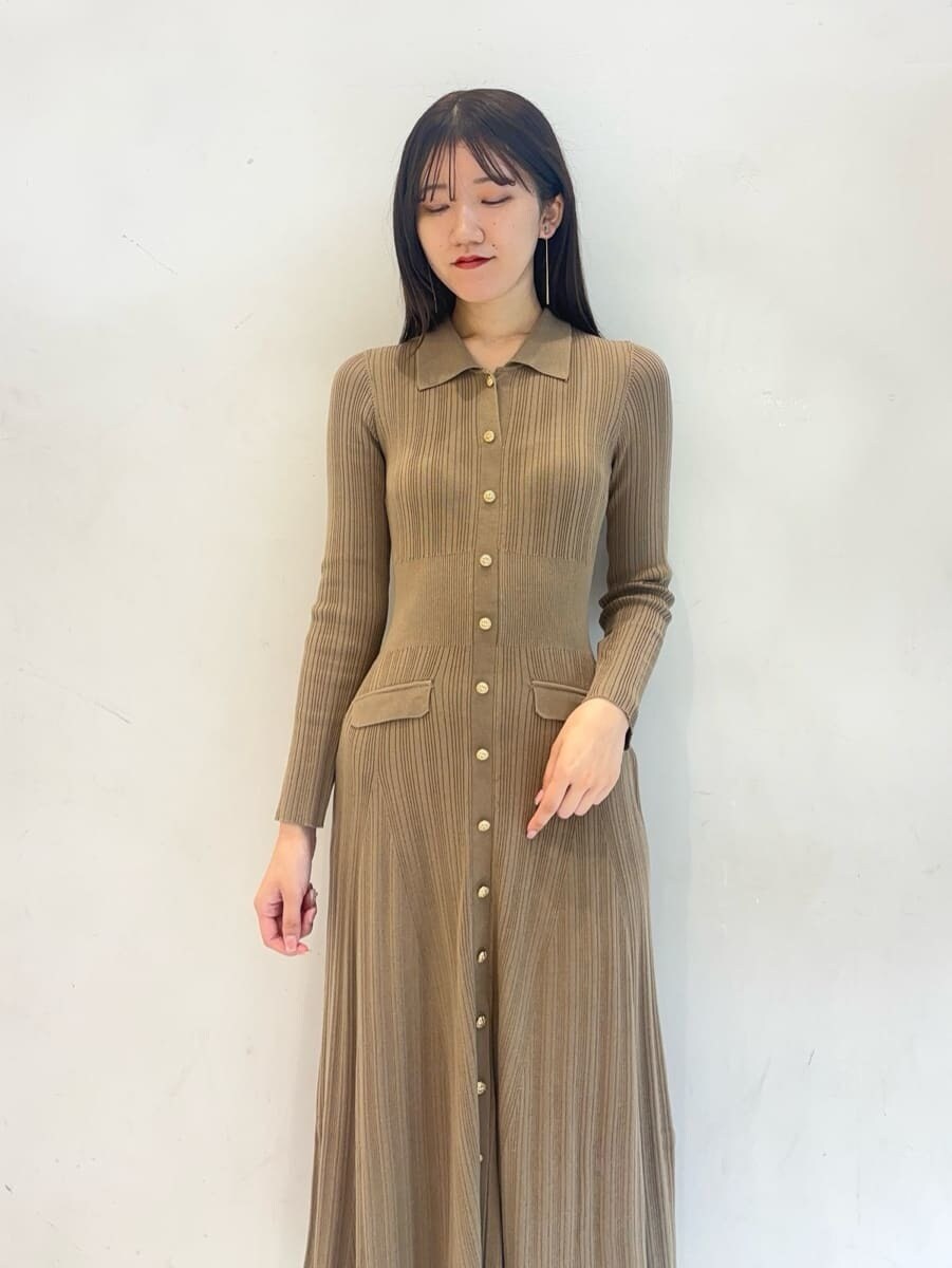 ホワイト系のチェスターコート、ベージュ系のワンピース、ホワイト系のボストンバッグを着用したレディースの秋コーディネートの8枚目の写真