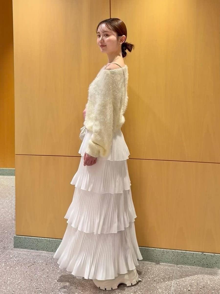 ホワイト系のショルダーバッグ、ホワイト系のブーツを着用したレディースの冬コーディネートの2枚目の写真