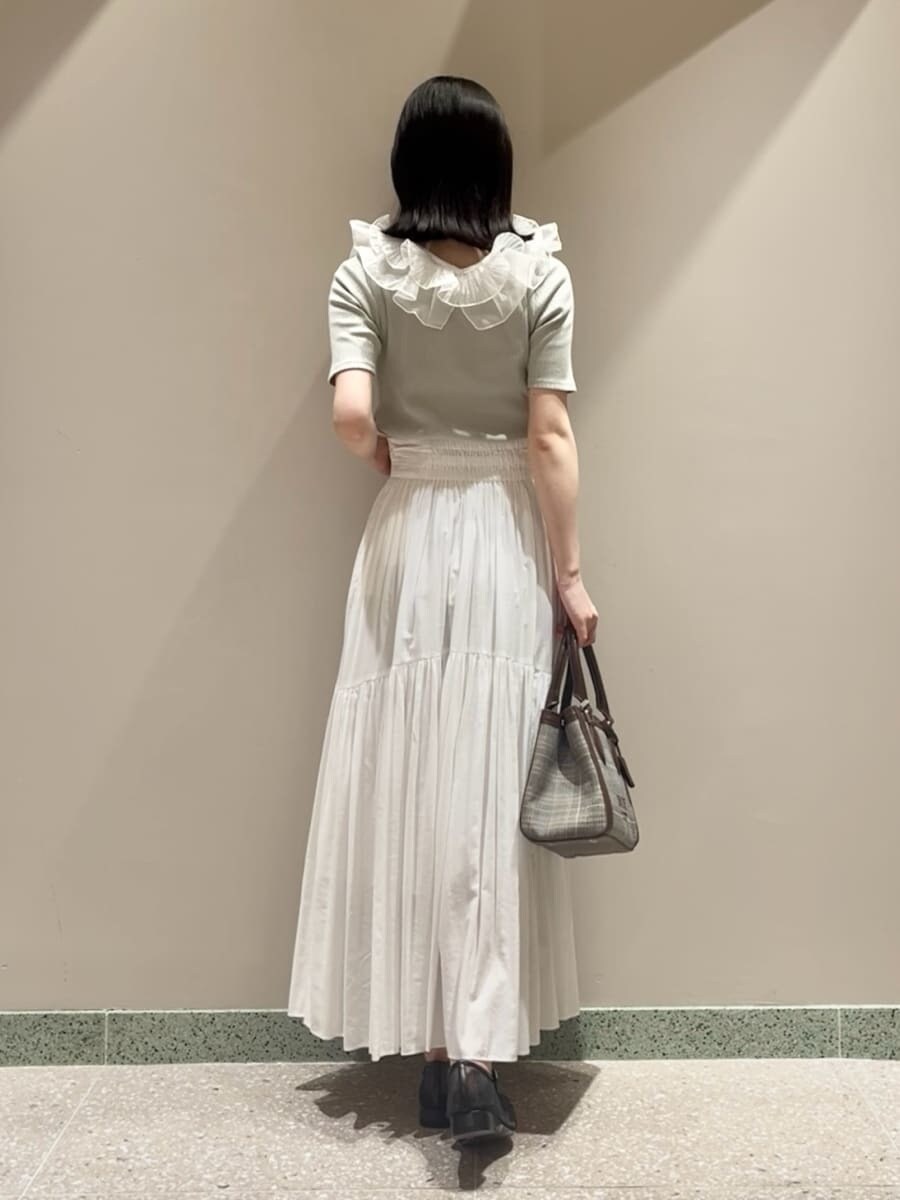 グリーン系のTシャツ/カットソー、ホワイト系のスカート、ブラウン系のハンドバッグを着用したレディースの夏コーディネートの3枚目の写真