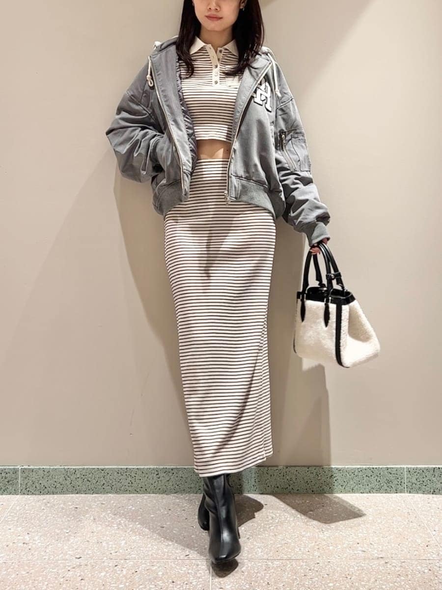 グレー系のブルゾン、ホワイト系のワンピース、ブラック系のハンドバッグを着用したレディースの秋コーディネートの2枚目の写真