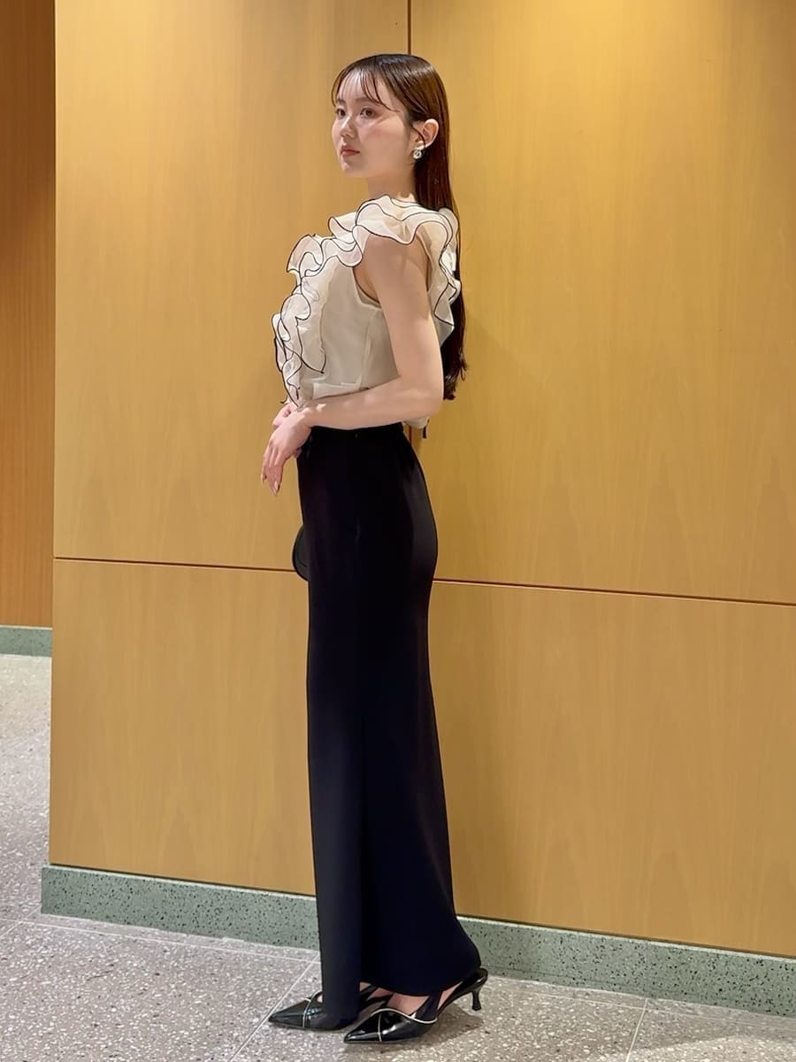 ブラック系のスカート、ベージュ系のシャツ/ブラウス、ブラック系のパンプスを着用したレディースの春コーディネートの2枚目の写真