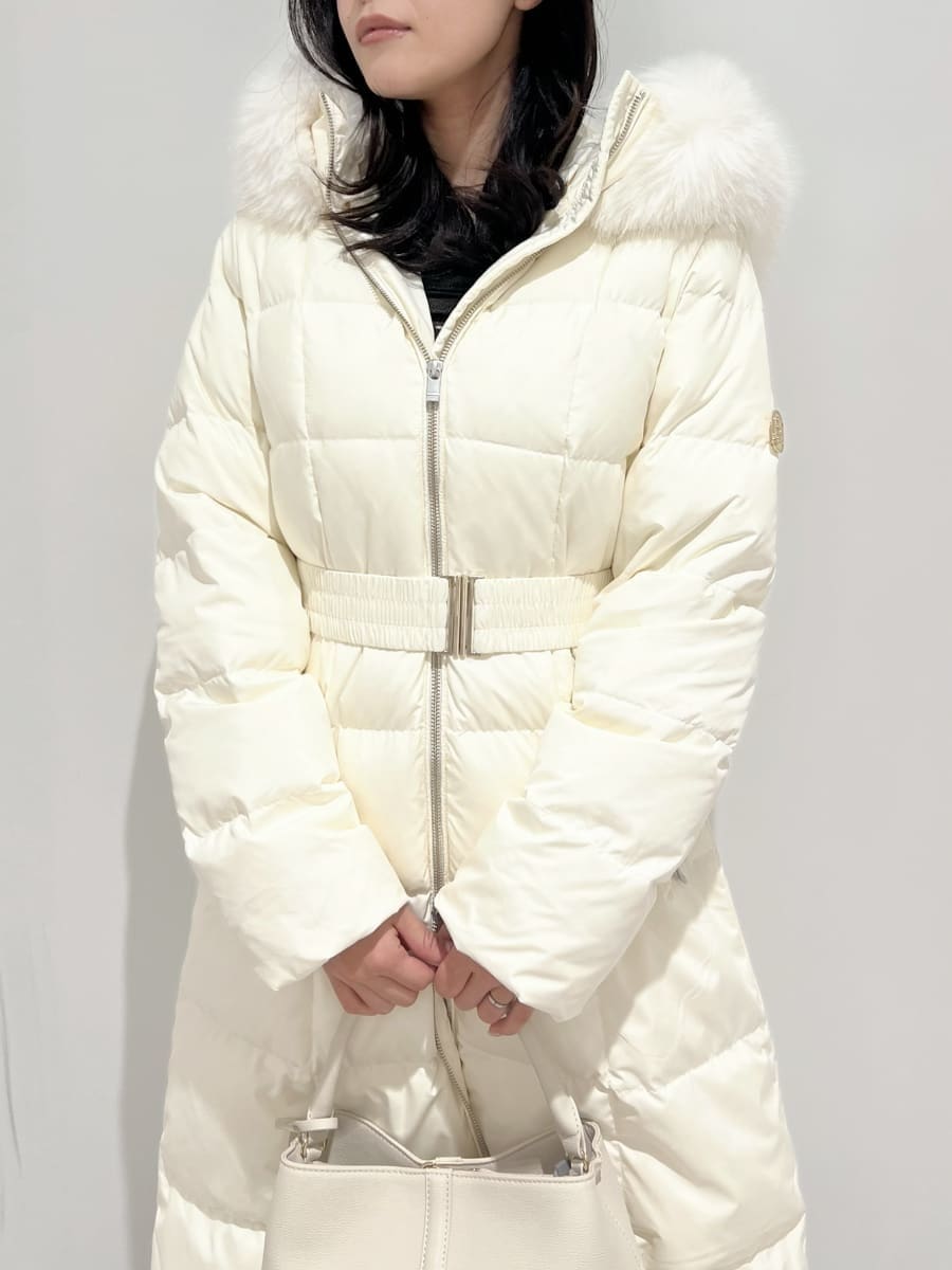 ホワイト系のダウンジャケット/コート、ホワイト系のブーツ、ホワイト系のハンドバッグを着用したレディースの冬コーディネートの4枚目の写真