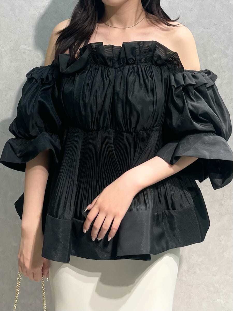 ホワイト系のスカート、ブラック系のその他トップス、ブラック系のパンプスを着用したレディースの春コーディネートの5枚目の写真