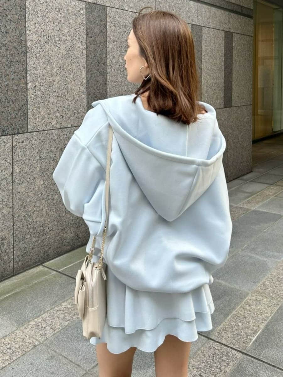 ブルー系のパーカー、ホワイト系のショルダーバッグ、ブルー系のその他パンツを着用したレディースの冬コーディネートの3枚目の写真