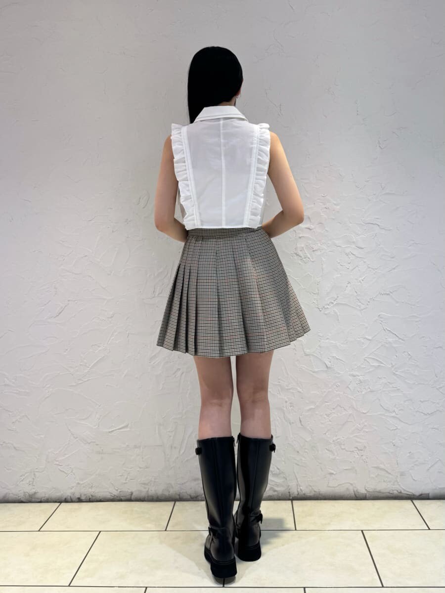 ホワイト系のシャツ/ブラウス、ベージュ系のスカート、ブラック系のブーツを着用したレディースの夏コーディネートの3枚目の写真